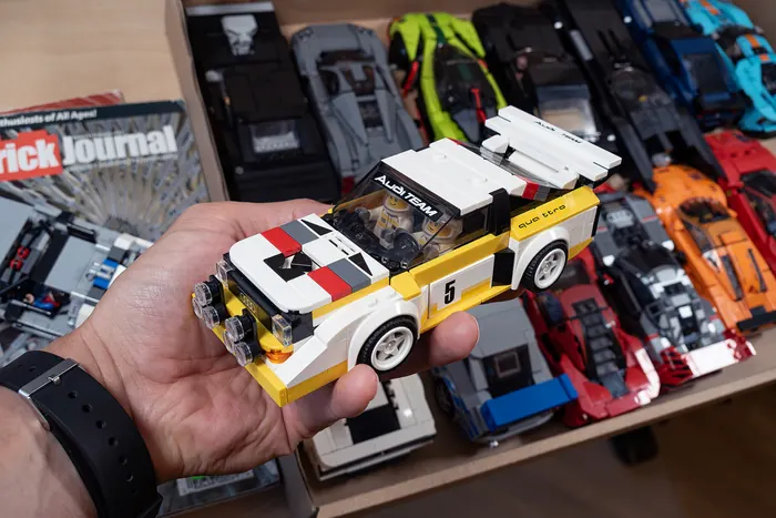 Custom LEGO Audi Quattro held in hand above a box of other builds