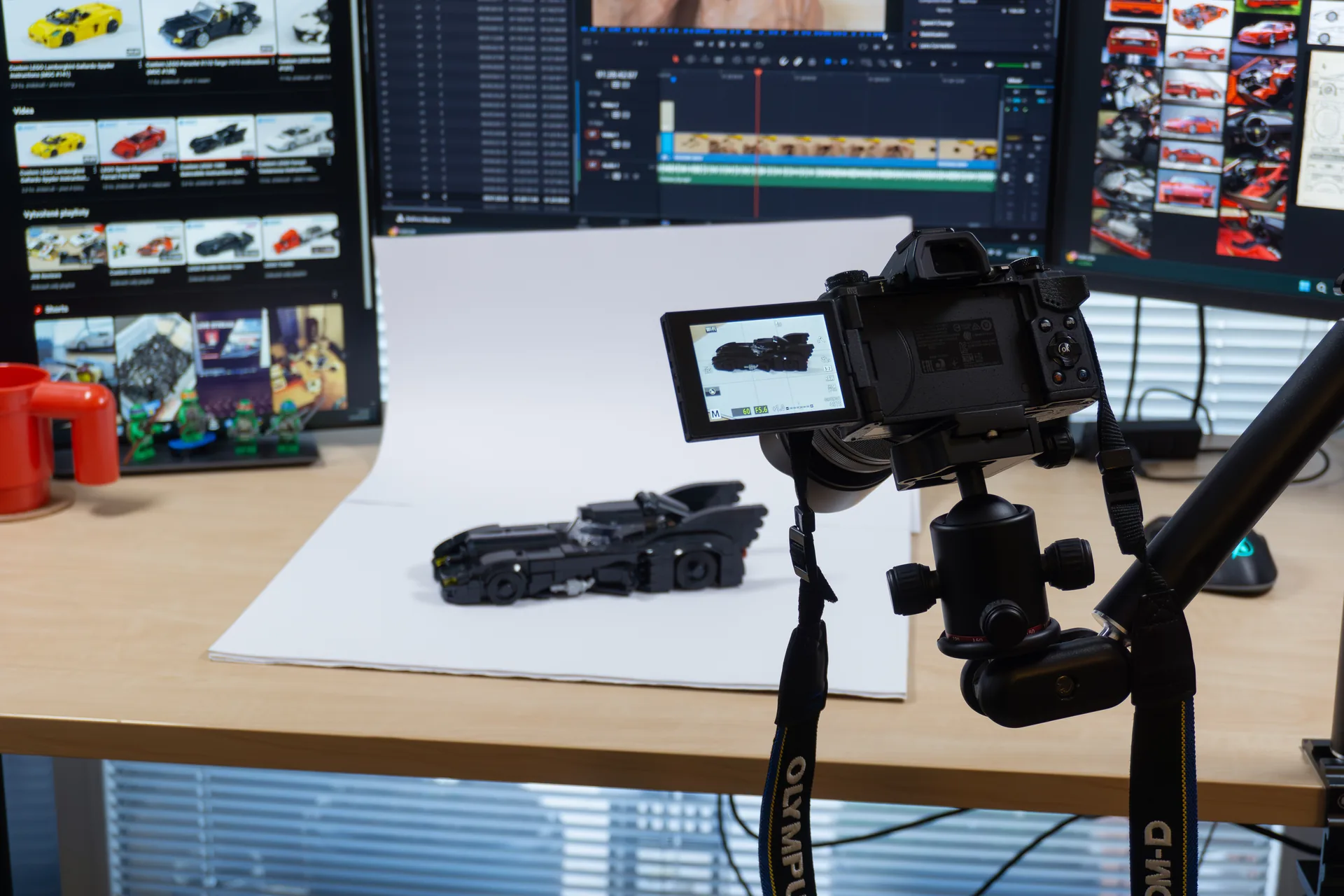 Jerry's photo setup with a camera on a tripod pointed at a custom LEGO Batmobile on a white backdrop