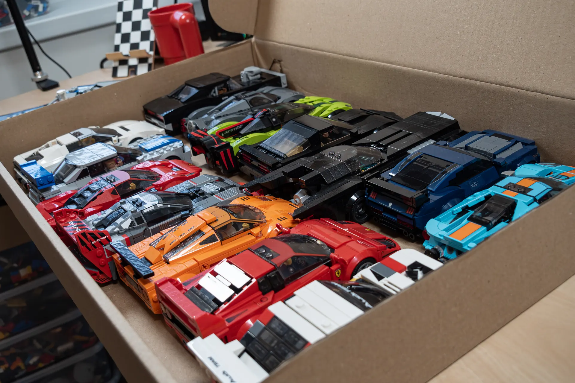 Box full of finished custom LEGO car builds